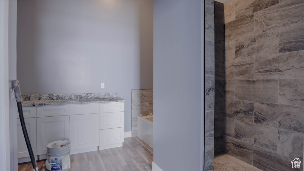 Bathroom featuring vanity, a washtub, and wood-type flooring