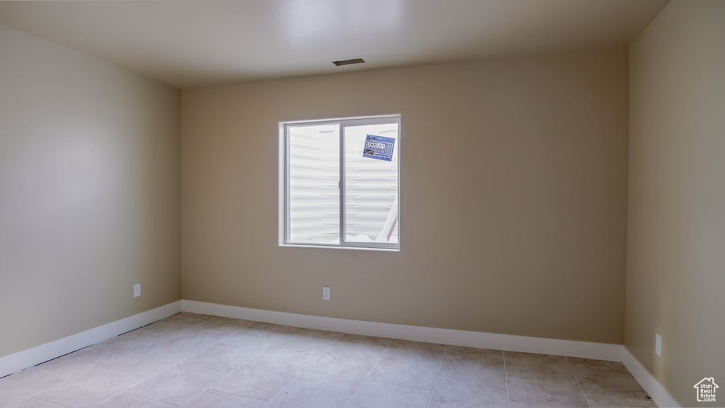 Tiled spare room with a wealth of natural light