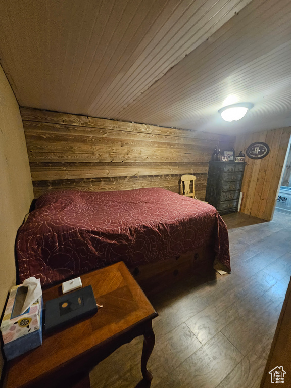 Bedroom featuring wooden ceiling and wooden walls