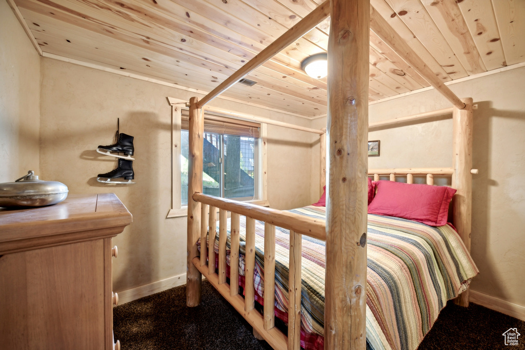 Bedroom featuring crown molding, wood ceiling, and carpet floors