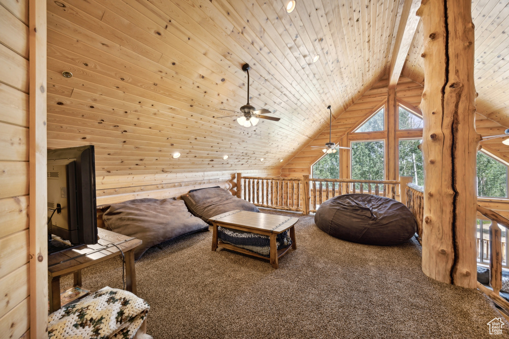 Living area featuring ceiling fan, carpet, lofted ceiling with beams, and plenty of natural light