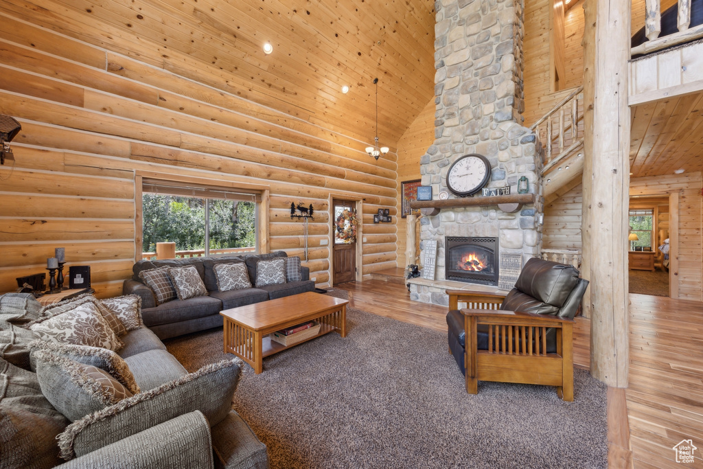 Living room featuring log walls, a fireplace, high vaulted ceiling, wooden ceiling, and wood-type flooring