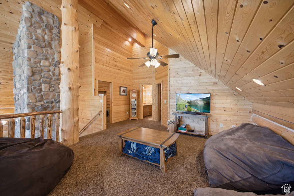 Living room featuring wood walls, wood ceiling, carpet floors, ceiling fan, and high vaulted ceiling