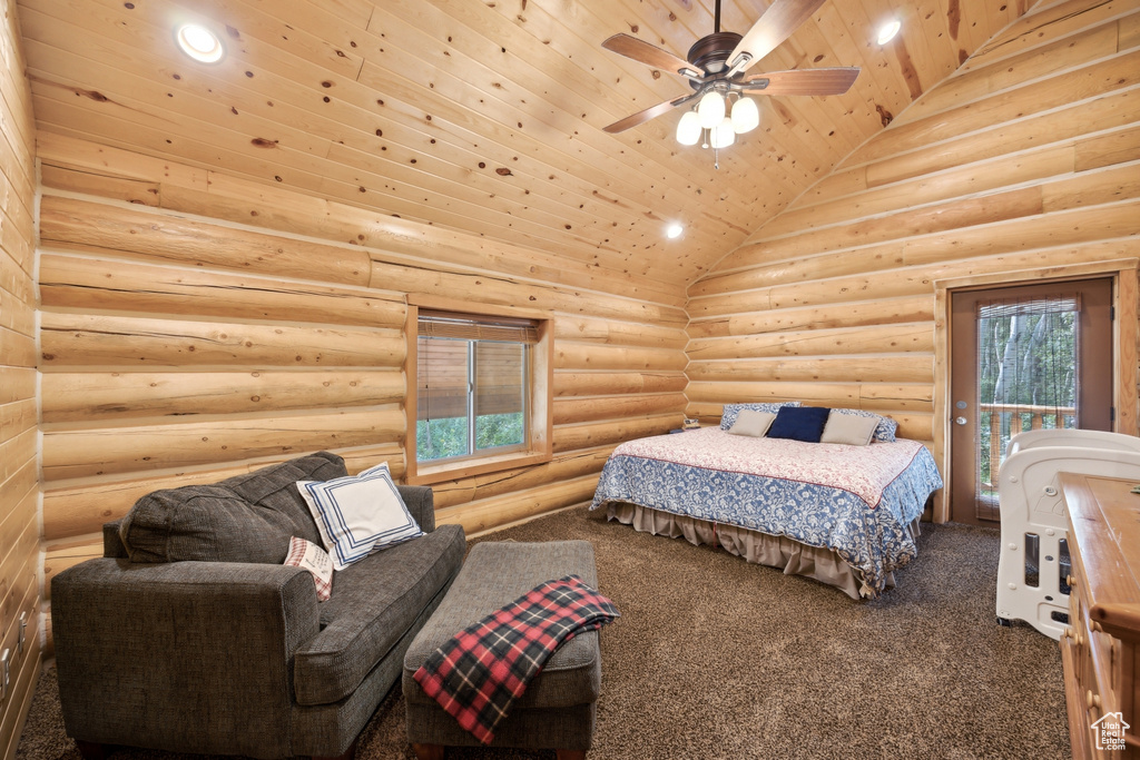 Carpeted bedroom with multiple windows, wooden ceiling, ceiling fan, and rustic walls