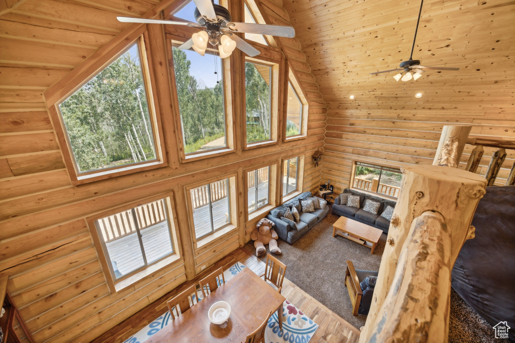 Living room featuring ceiling fan, a healthy amount of sunlight, and high vaulted ceiling