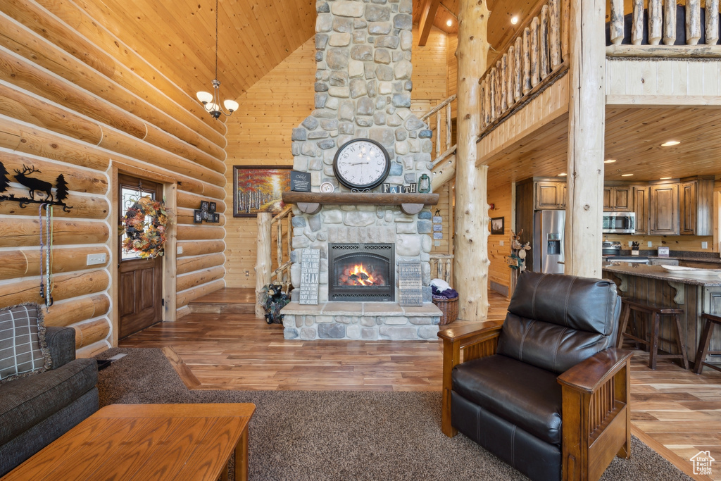 Living room featuring wooden ceiling, light hardwood / wood-style floors, high vaulted ceiling, and rustic walls