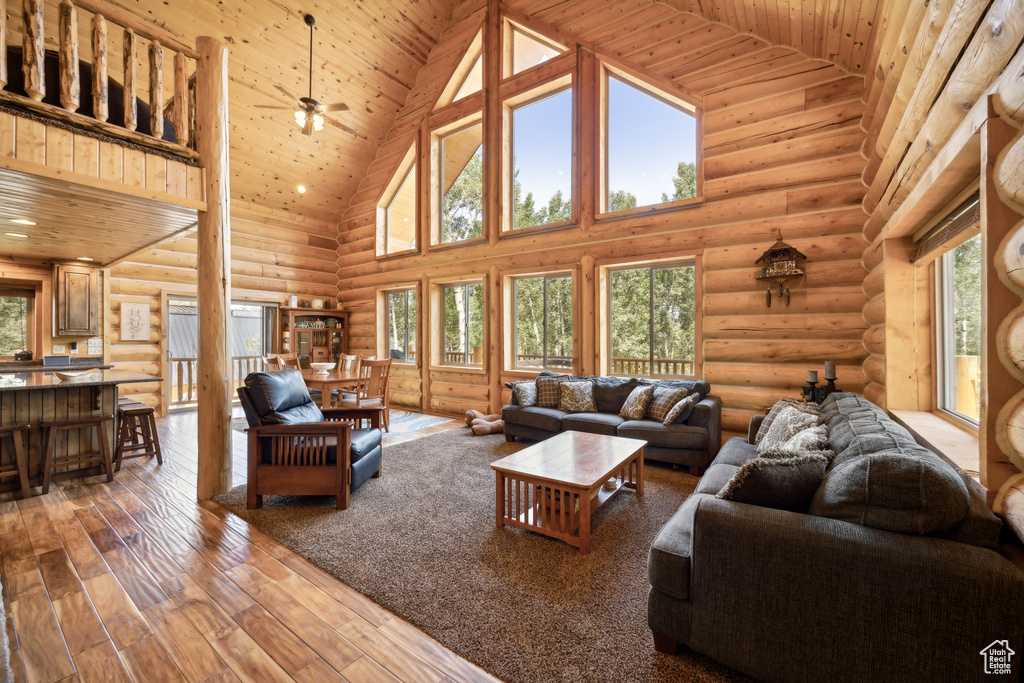 Living room with ceiling fan, hardwood / wood-style flooring, wooden ceiling, and high vaulted ceiling