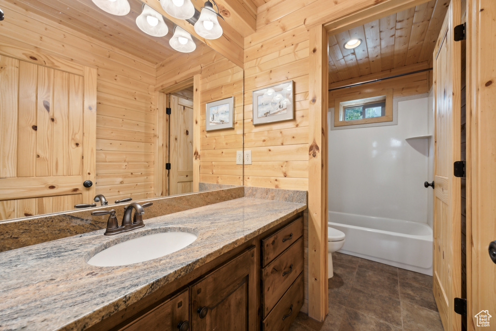 Full bathroom with wood walls, wooden ceiling, and toilet