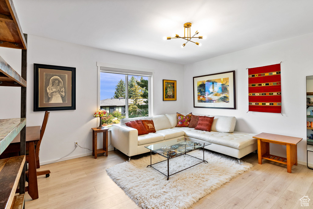 Living room featuring a notable chandelier and light wood-type flooring