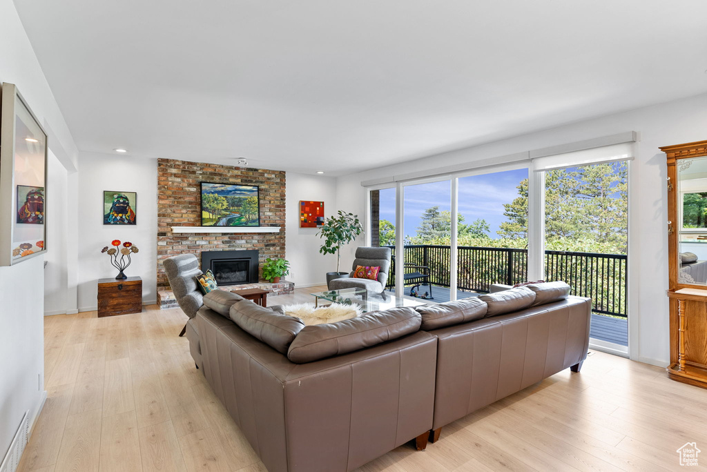 Living room with light hardwood / wood-style floors and a brick fireplace