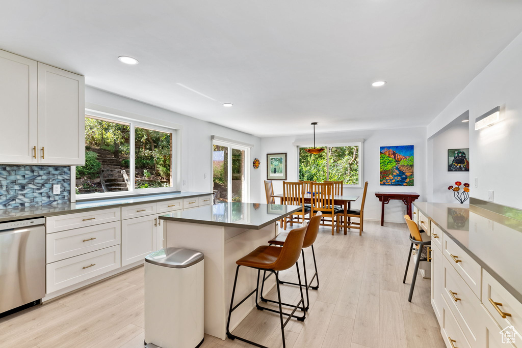 Kitchen with white cabinets, a wealth of natural light, and stainless steel dishwasher