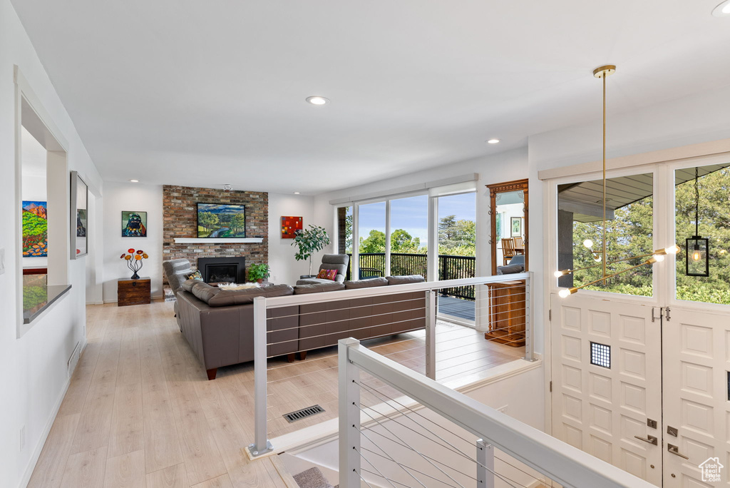 Living room with a fireplace and light hardwood / wood-style flooring