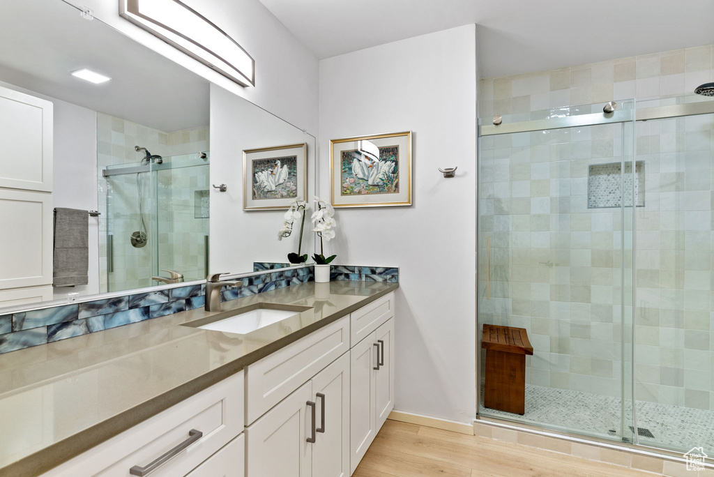 Bathroom with vanity, an enclosed shower, and hardwood / wood-style flooring