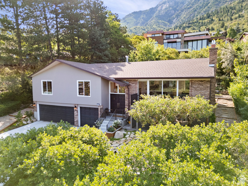 View of front of house with a mountain view and a garage