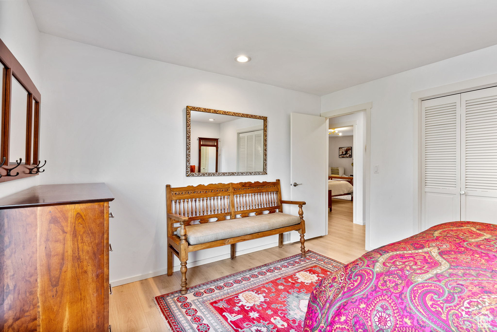 Bedroom with light hardwood / wood-style floors and a closet