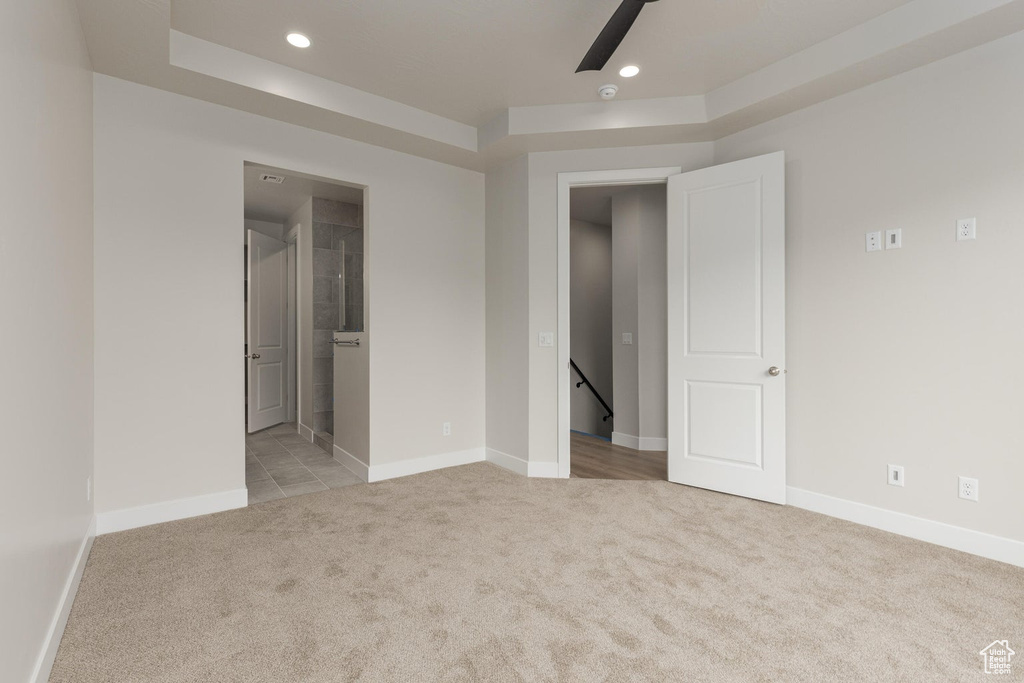 Carpeted empty room featuring a raised ceiling