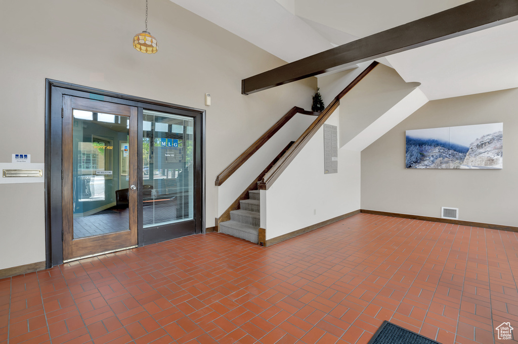 Interior space with beamed ceiling and french doors