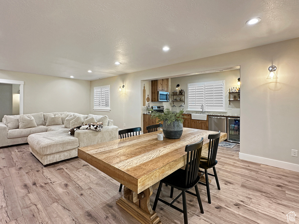 Dining room featuring sink, wine cooler, and light hardwood / wood-style floors