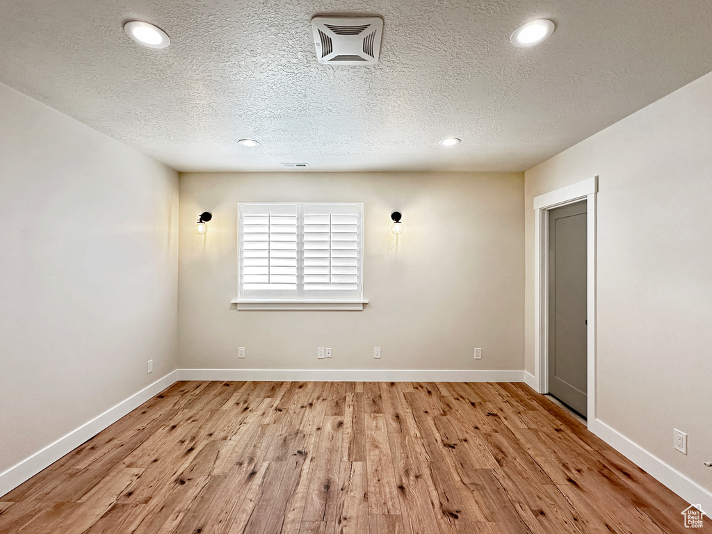 Spare room featuring a textured ceiling and light wood-type flooring