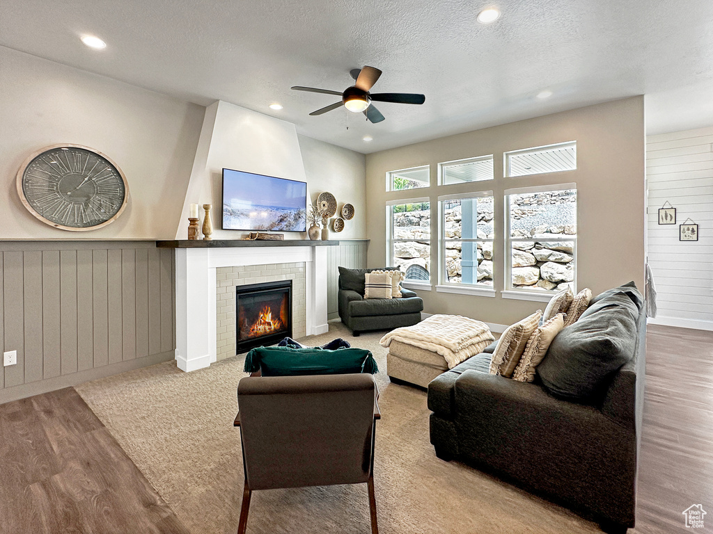 Living room with light hardwood / wood-style floors, a textured ceiling, and ceiling fan