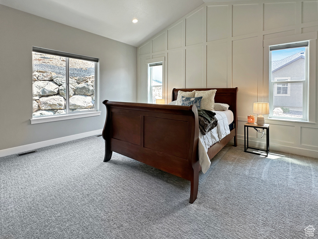 Bedroom featuring lofted ceiling and light colored carpet