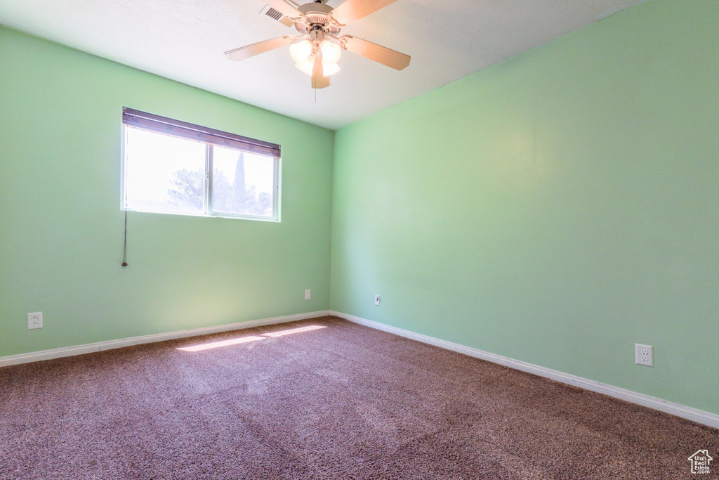 Carpeted empty room featuring ceiling fan