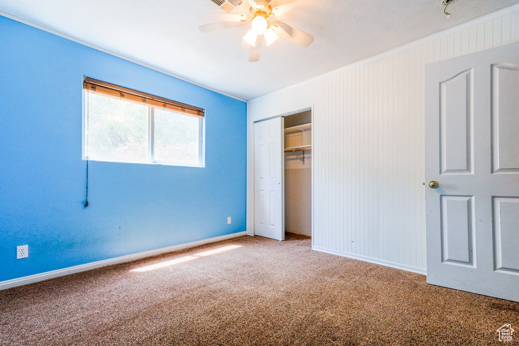 Unfurnished bedroom with carpet, ceiling fan, and a closet