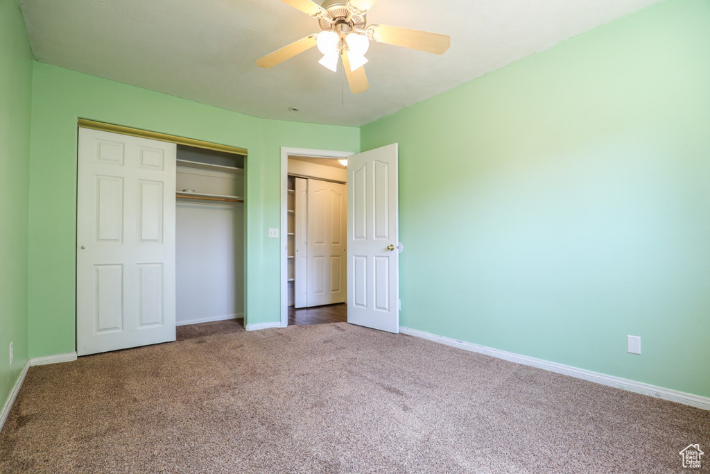 Unfurnished bedroom featuring carpet flooring, a closet, and ceiling fan