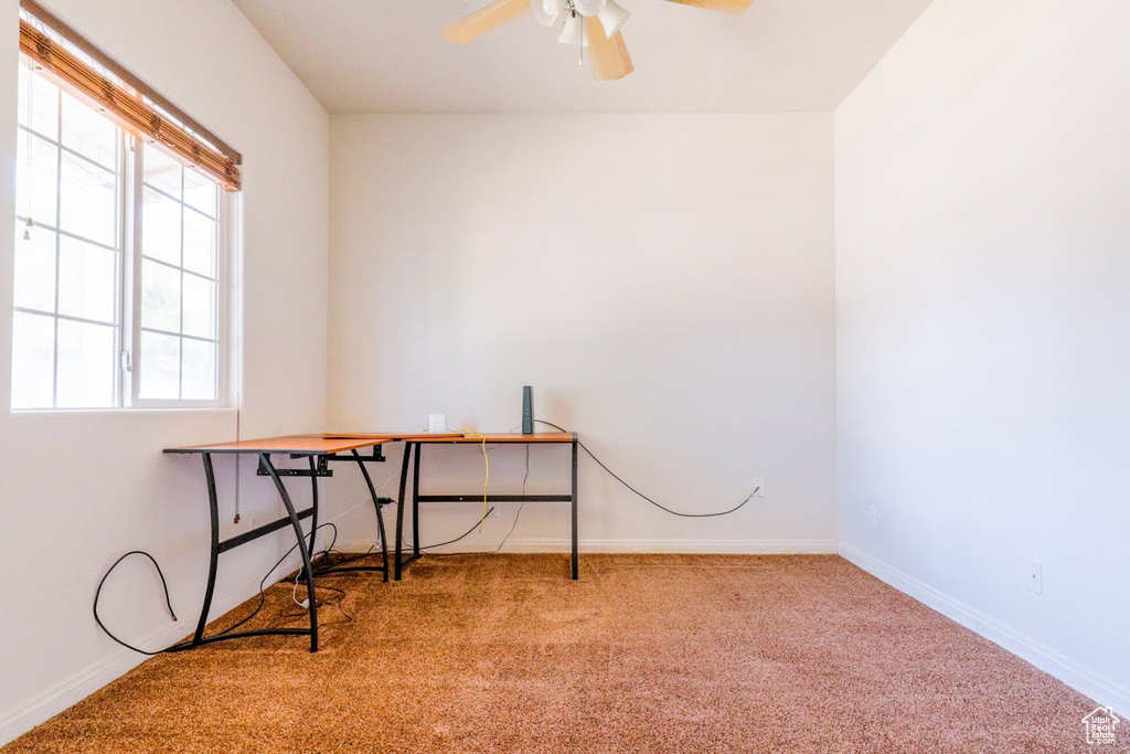 Carpeted office space featuring ceiling fan