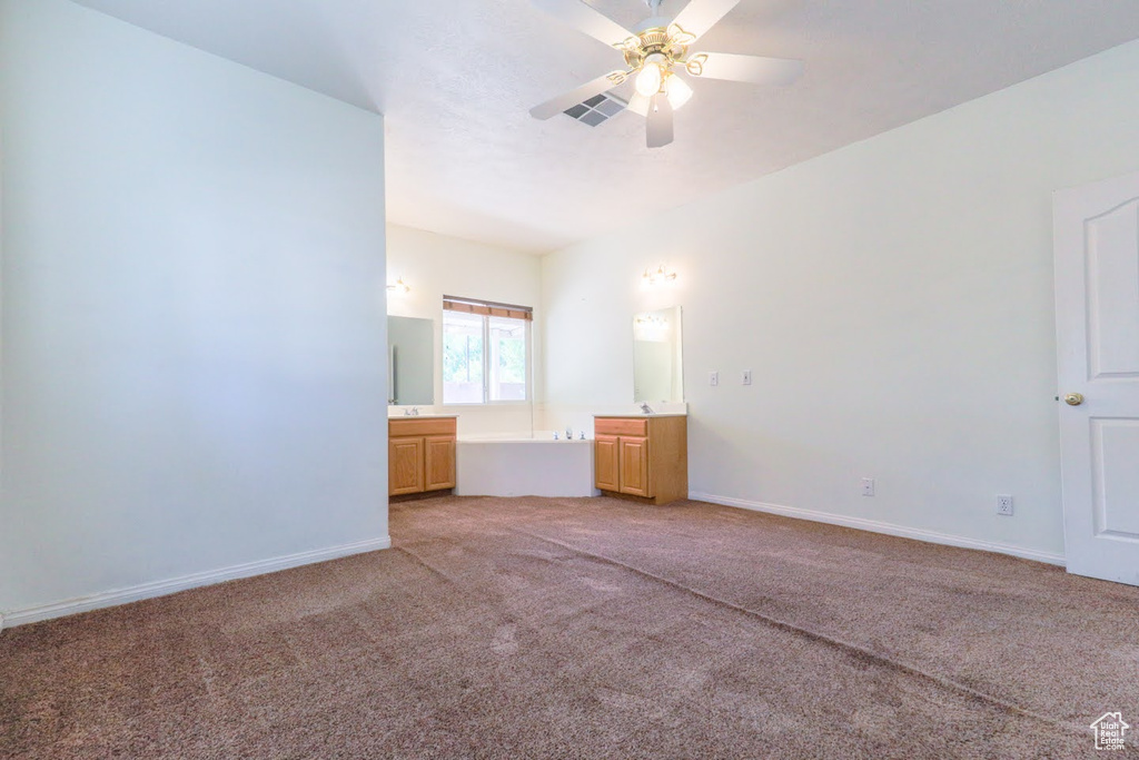 Unfurnished bedroom featuring light colored carpet and ceiling fan