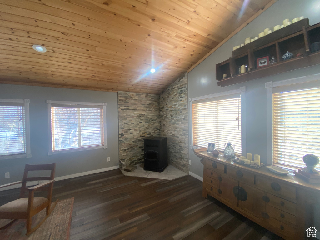 Living room featuring a wood stove, wooden ceiling, dark hardwood / wood-style floors, a wealth of natural light, and lofted ceiling