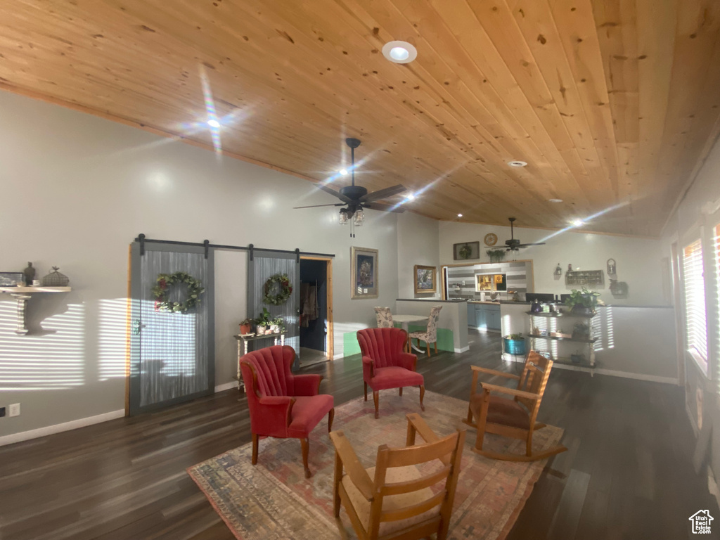 Living room featuring hardwood / wood-style flooring, a barn door, ceiling fan, and wood ceiling