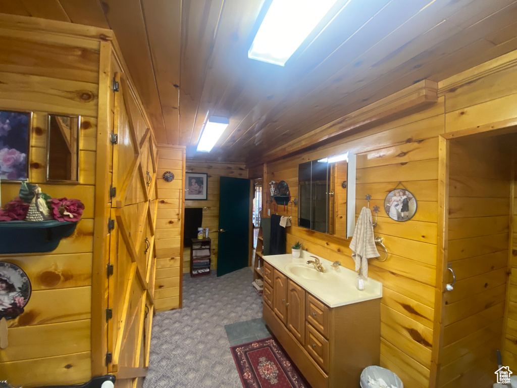 Bathroom featuring wood walls, wood ceiling, and vanity