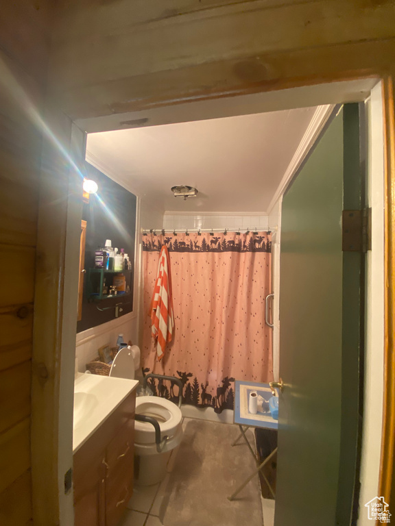 Bathroom featuring ornamental molding, vanity, tile patterned floors, and toilet