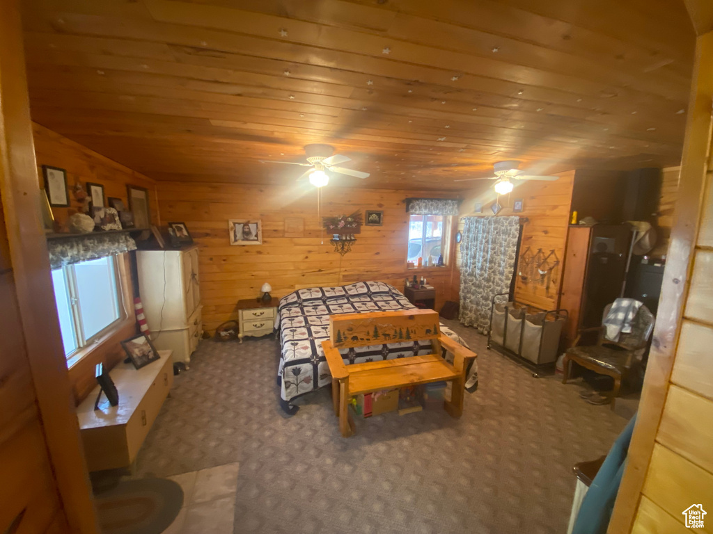 Recreation room with wood ceiling, wood walls, carpet, and ceiling fan