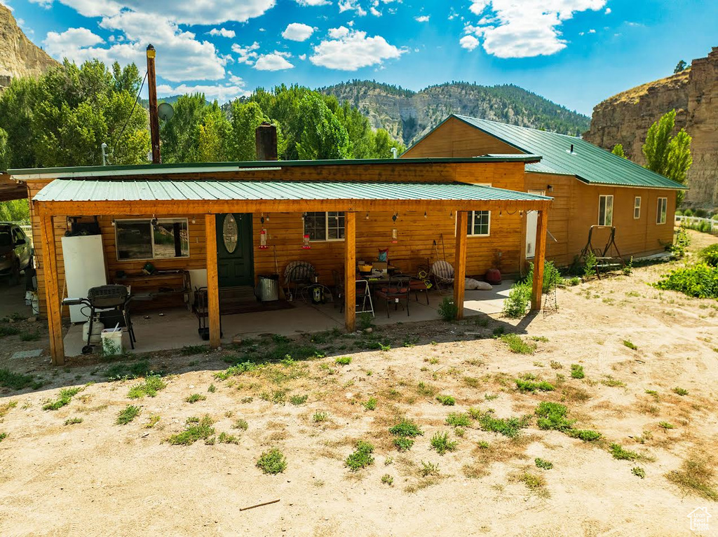 Back of property featuring a patio and a mountain view