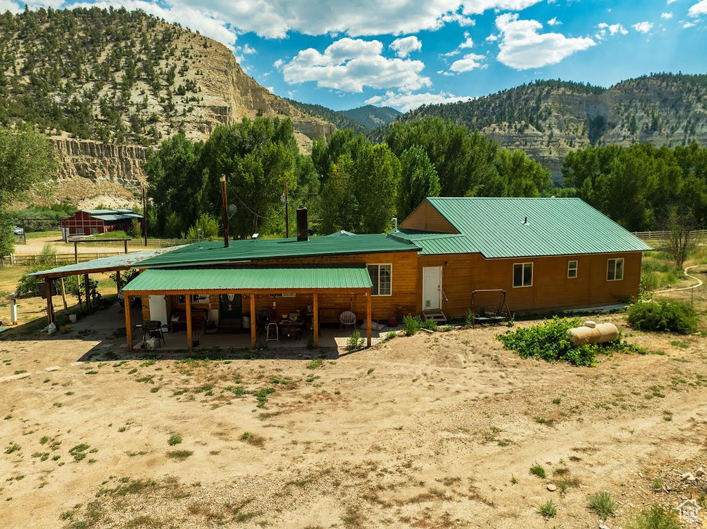 Back of house featuring a mountain view and a patio area