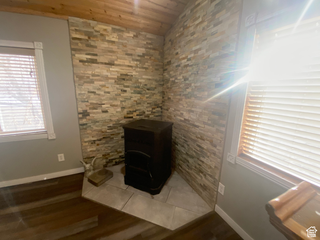 Interior details featuring wooden ceiling, tile patterned floors, and a wood stove