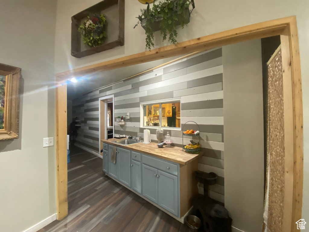 Bar with sink, wooden counters, and dark wood-type flooring