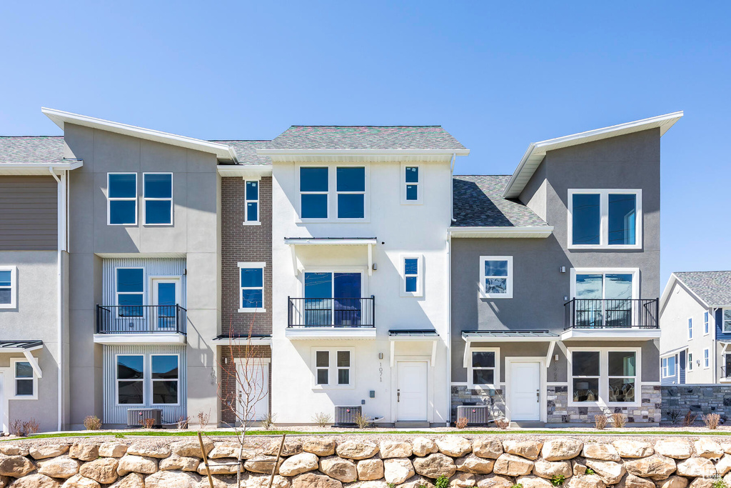 Rear view of property with a balcony and central air condition unit