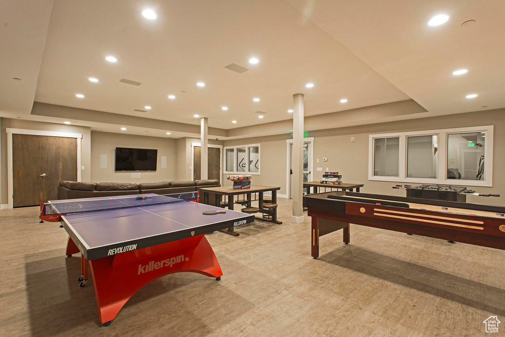 Recreation room featuring a raised ceiling and light wood-type flooring