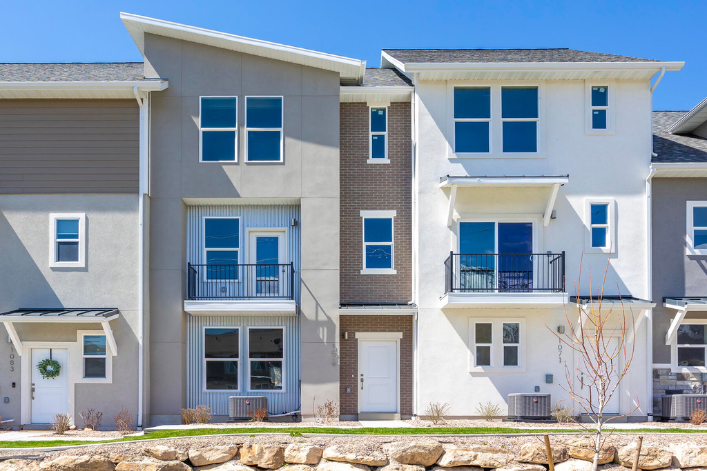 Townhome / multi-family property featuring a balcony and central AC unit