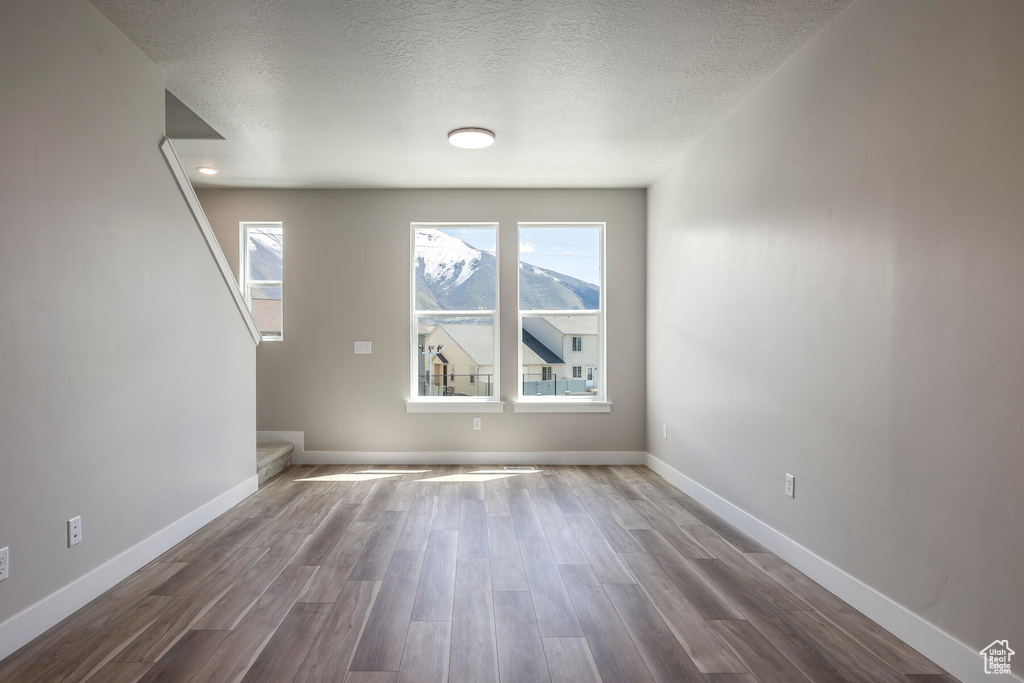 Additional living space featuring a textured ceiling and hardwood / wood-style floors