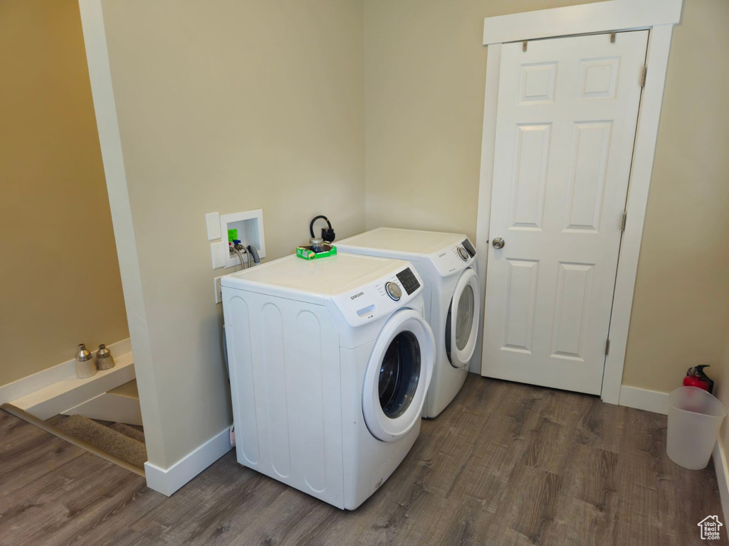 Laundry area featuring dark wood-type flooring and washing machine and clothes dryer