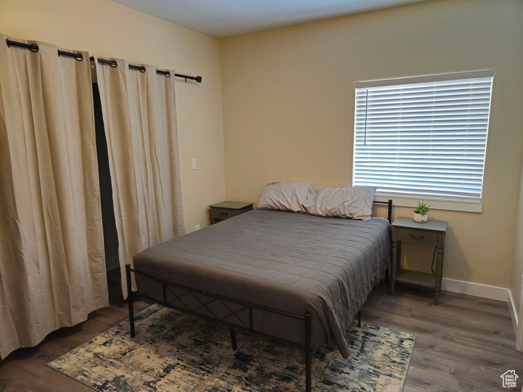 Bedroom with dark hardwood / wood-style flooring