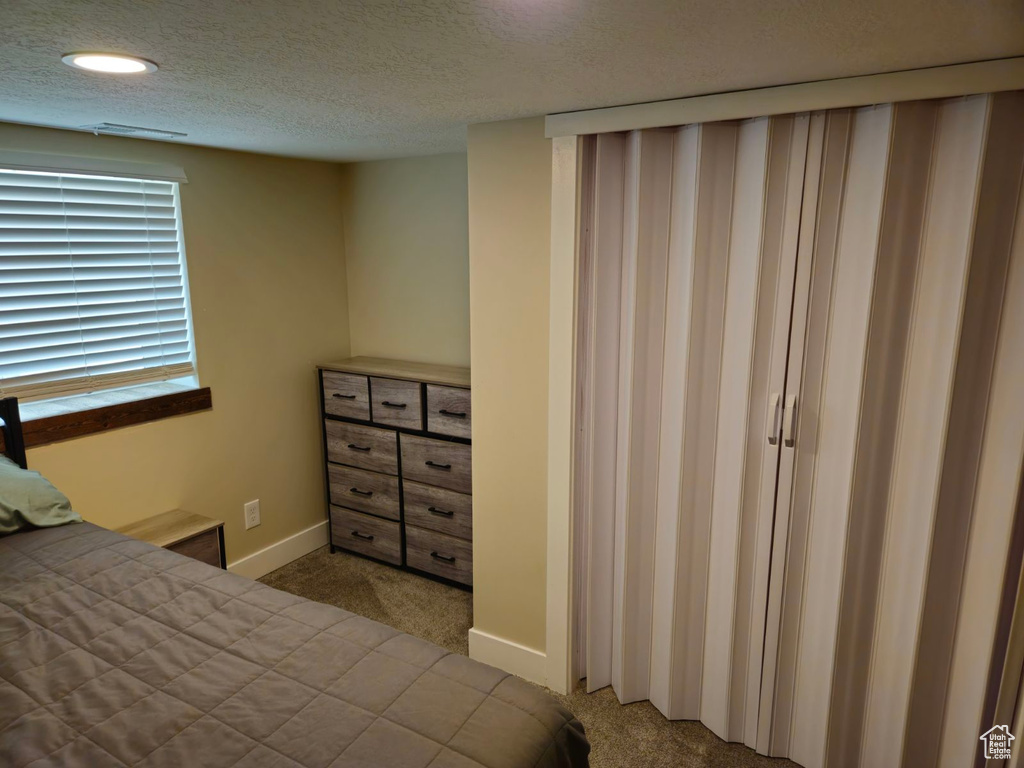 Unfurnished bedroom featuring carpet flooring and a textured ceiling