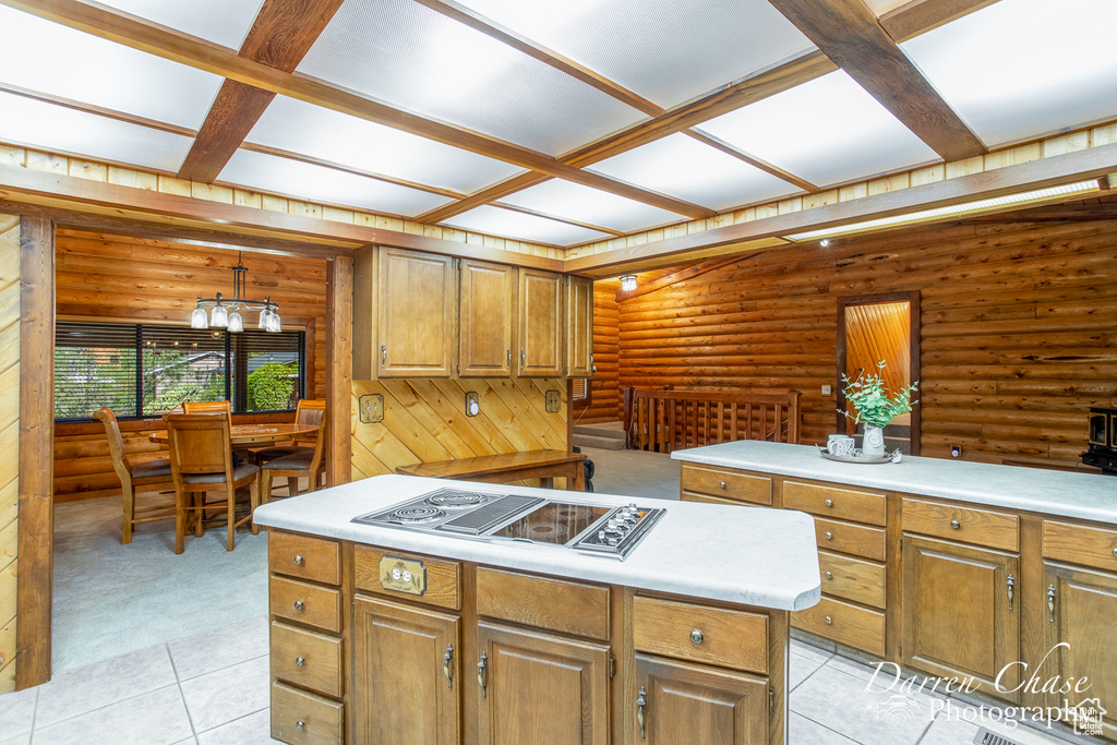 Kitchen featuring a chandelier, rustic walls, electric cooktop, coffered ceiling, and light tile patterned floors