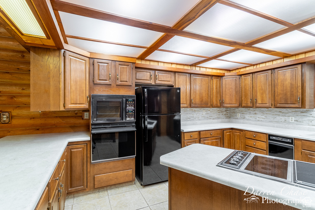 Kitchen with backsplash, black appliances, and light tile patterned floors