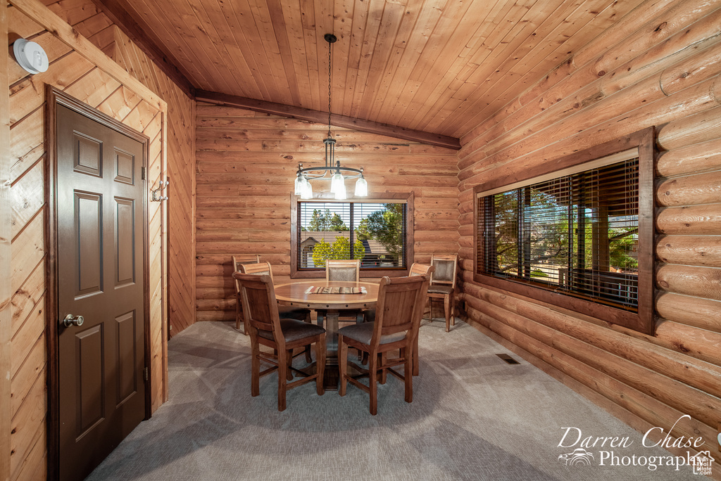 Carpeted dining space featuring an inviting chandelier, lofted ceiling, rustic walls, and wood ceiling