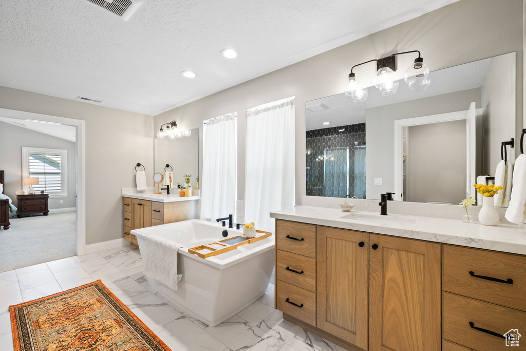 Bathroom with tile patterned flooring, a bathing tub, and vanity